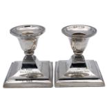 A pair of George V silver squat candlesticks.