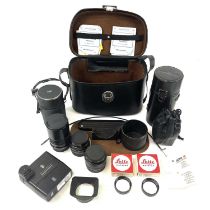 A leather camera case containing Leica camera lenses and camera attachments.