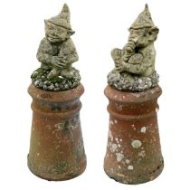 A pair of reconstituted stone Cornish Piskies on shell encrusted bases.