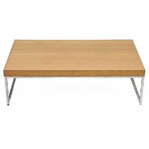 A birch veneered low coffee table on chrome supports.