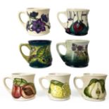 A collection of seven Moorcroft Pottery mugs.