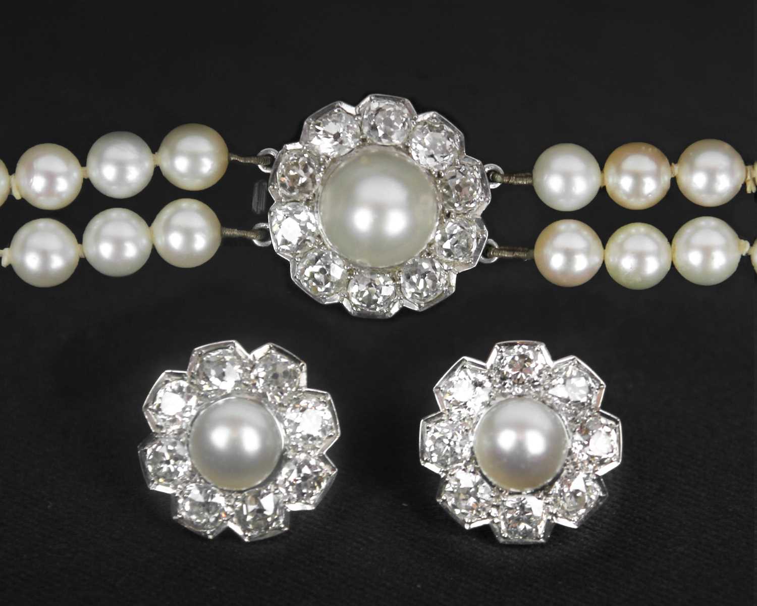 An impressive early 20th century cultured pearl, diamond set, double-row necklace & earrings suite.