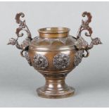 A 19th Century Japanese bronze twin handled vase with roundel decoration, raised on a circular