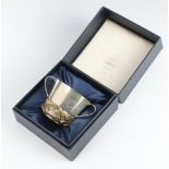 Stuart Devlin, a cast silver and silver gilt commemorative Royal Christening 2 handled porringer