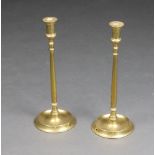 A pair of 19th Century brass candlesticks, raised on circular spreading bases 44cm x 17cm (both feet
