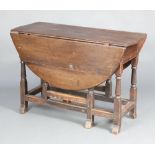 A 17th/18th Century oval oak gateleg drop flap dining table fitted a frieze drawer, raised on turned