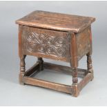 An Ipswich style carved oak stool/box with hinged lid, raised on turned and block supports 51cm x