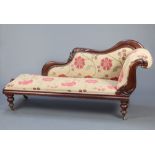 A Victorian mahogany show frame chaise longue upholstered in floral patterned material raised on