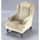 A Victorian armchair upholstered in green material, on turned supports 194cm h x 72cm w x 71cm d