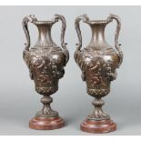 An impressive pair of Victorian spelter twin handled urns, the bodies decorated cherubs raised on