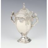 A cast silver trophy cup and cover with caryatid handles and cast mask detail, London 1936, 15cm,