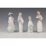 A Lladro figure of a girl holding a lamb 23cm, ditto of a kneeling girl 4673 17cm, a boy 23cm and