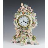 A 20th Century German porcelain rococo style clock with applied flowers and cherubs, raised on a