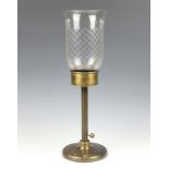 A bronze table lamp with adjustable stem, having a flared cut glass shade 54cm