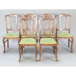 A set of 6 French oak tulip back dining chairs with upholstered drop in seats, raised on cabriole