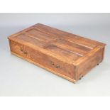 A 1930's rectangular panelled oak underbed storage unit raised on casters 26cm h x 118cm w x 63cm d