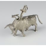 A white metal figure of a bull with 3 ditto cocktail stick swords 8.5cm