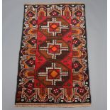 A brown, black and orange Belouche rug with 3 octagons to the centre 145cm x 88cm