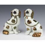 A pair of Victorian Staffordshire spaniels with separate front leg with gilt decoration 22cm