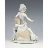 A Lladro group of a lady, boy and goose 24cm