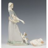 A Lladro figure of a girl holding a goose with a dog at her feet 28cm together with a Royal