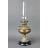 A 19th Century brass oil lamp with ceramic base and clear glass chimney 57cm h x 17cm diam.