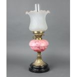 A Victorian pink opaque glass oil lamp reservoir, raised on an embossed gilt metal and ceramic