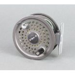 An Orvis Battenkill 8/9 salmon fishing reel with blue cloth pouch