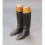 A pair of black leather riding boots complete with beech trees Boots are crackled in places
