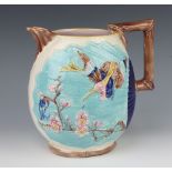 A Victorian Majolica style jug with rustic handle decorated with birds amongst peony 22cm Crack to