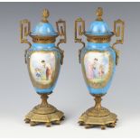 A pair of Sevres style blue ground twin handled vases with panels of figures and gilt metal mounts
