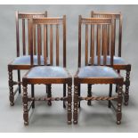 A set of 4 1930's oak stick and rail back dining chairs with upholstered drop in seats, raised on