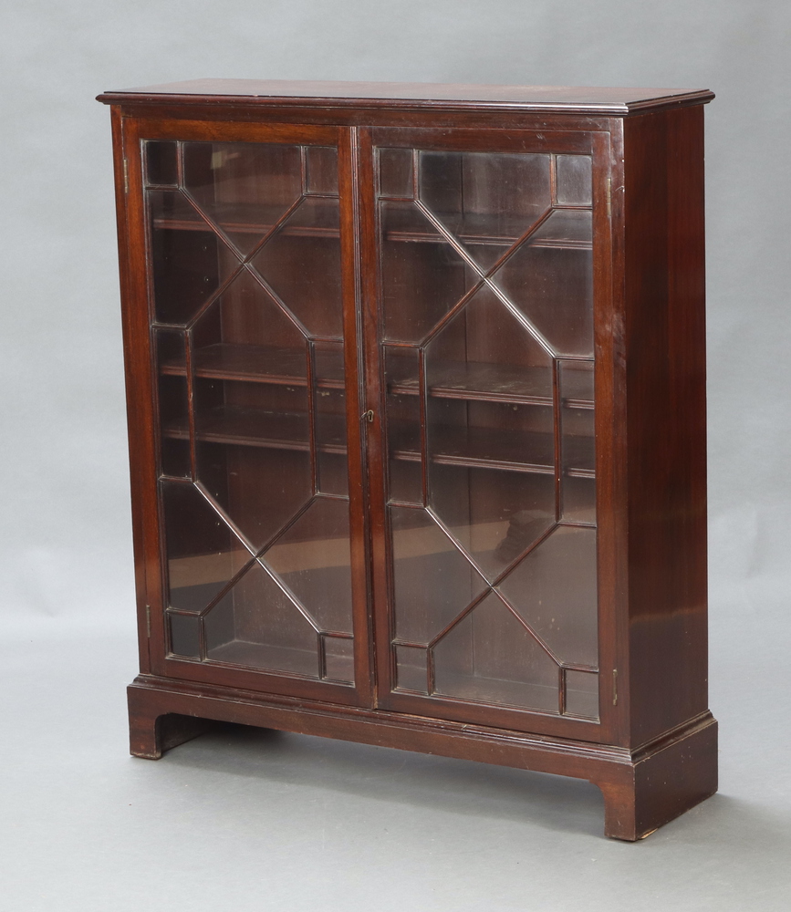 A Georgian style mahogany bookcase, fitted shelves enclosed by astragal glazed panelled doors,