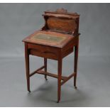 A Victorian inlaid rosewood Davenport with raised back, fitted a pen and 2 inkwell apertures, the