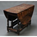 An 18th Century oval oak drop flap gateleg dining table fitted a frieze drawer, raised on turned