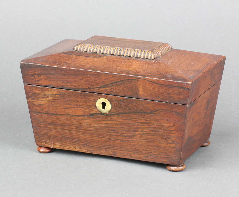 A 19th Century rosewood twin compartment tea caddy of sarcophagus form with brass escutcheon, raised