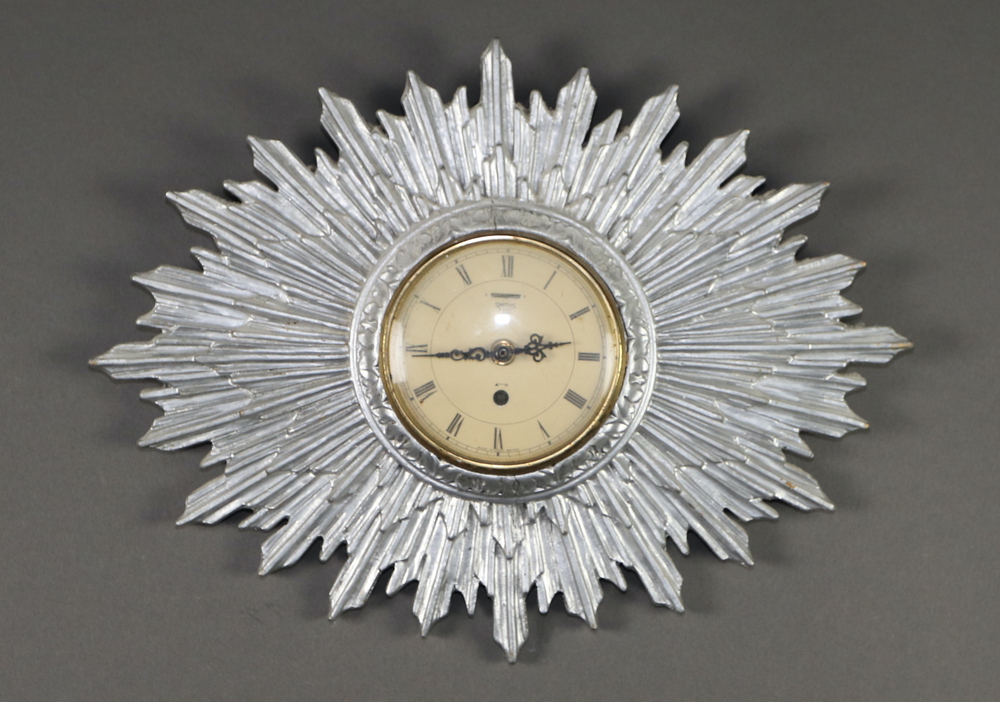 A 1940's 8 day wall timepiece, the 12cm paper dial with Roman numerals, contained in a silver