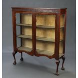 An Edwardian Chippendale style mahogany display cabinet with blind fret work decoration, raised on