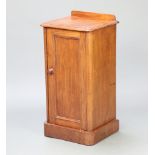 A Victorian mahogany pot cupboard with raised back, fitted a shelf enclosed by a panelled door,