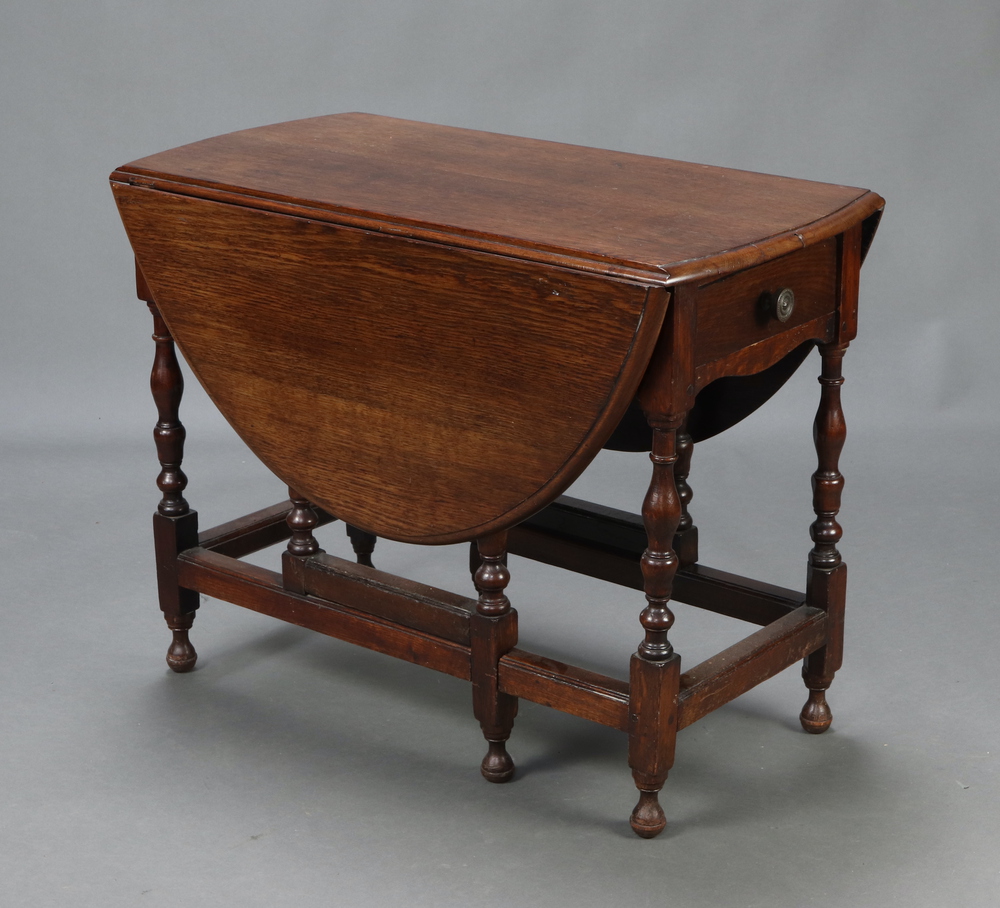 An 18th Century oval drop flap gateleg dining table fitted a drawer, raised on turned supports