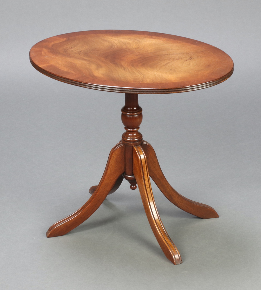 A Georgian style oval crossbanded mahogany snap top wine table, raised on a pillar and tripod base