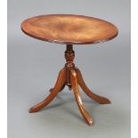 A Georgian style oval crossbanded mahogany snap top wine table, raised on a pillar and tripod base