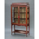 An Edwardian inlaid mahogany display cabinet with shaped top, fitted shelves enclosed by astragal
