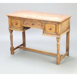 An Ipswich style bleached and carved oak side table fitted 1 long and 2 short drawers, raised on