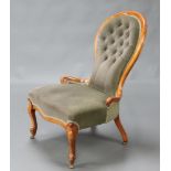 A Victorian mahogany show frame spoon back nursing chair raised on cabriole supports, upholstered in