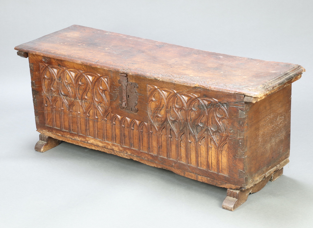 A 16th and later Century Spanish Gothic carved fruitwood coffer with iron hinged lid and shaped iron