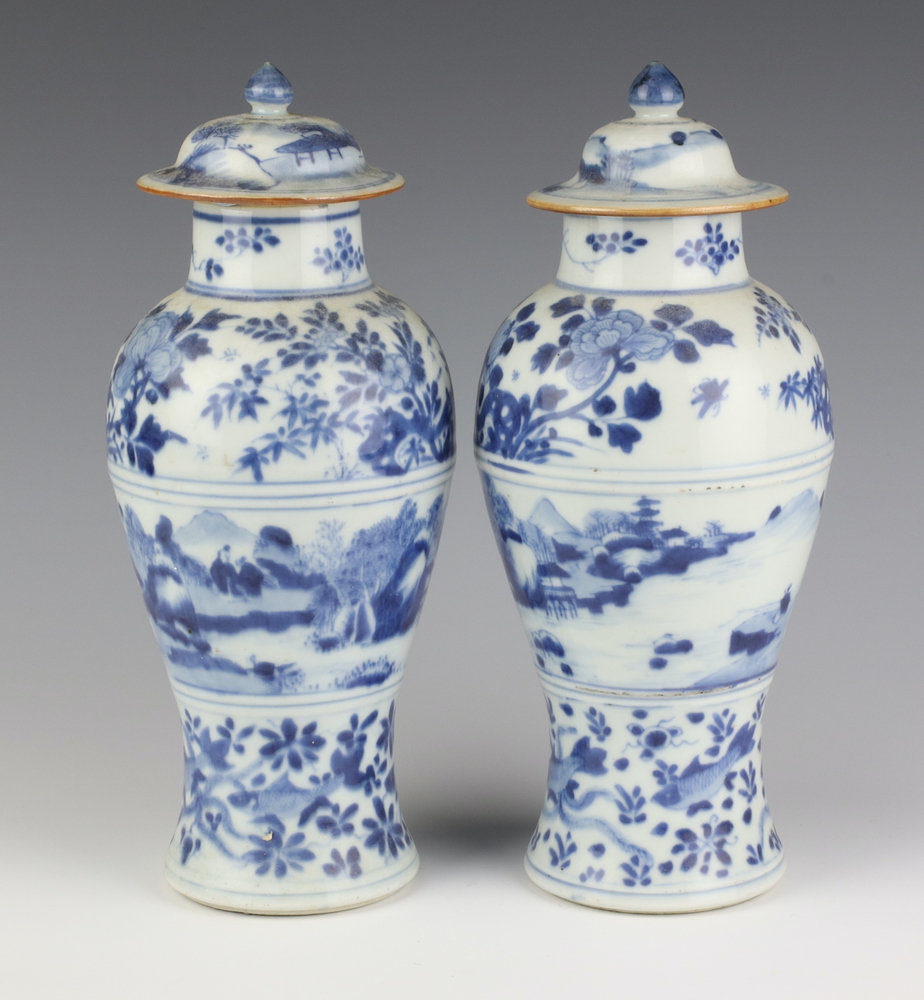 A pair of 19th Century Chinese blue and white oviform vases and covers decorated with a band of a