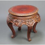 A Chinese circular carved hardwood jardiniere stand with deep carving to the apron, raised on