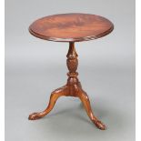 A circular Georgian style carved mahogany wine table raised on a pillar and tripod base with egg and