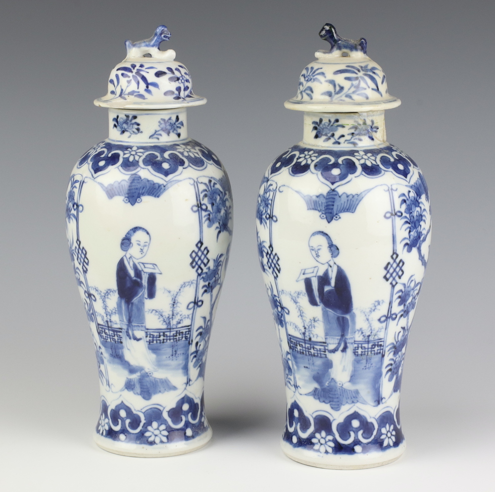 A pair of Chinese 19th Century blue and white oviform vases decorated with figures on a balcony with